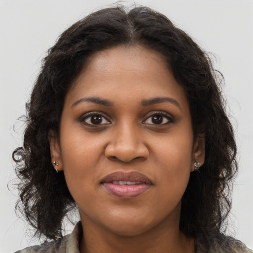 Joyful black young-adult female with long  brown hair and brown eyes