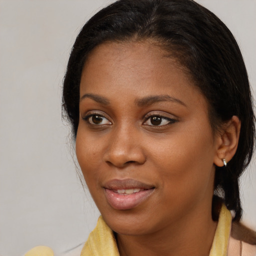 Joyful black young-adult female with long  brown hair and brown eyes