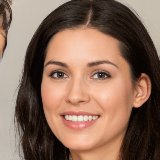 Joyful white young-adult female with long  brown hair and brown eyes