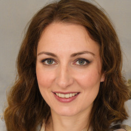 Joyful white young-adult female with medium  brown hair and green eyes