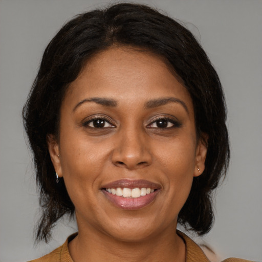 Joyful black young-adult female with medium  brown hair and brown eyes