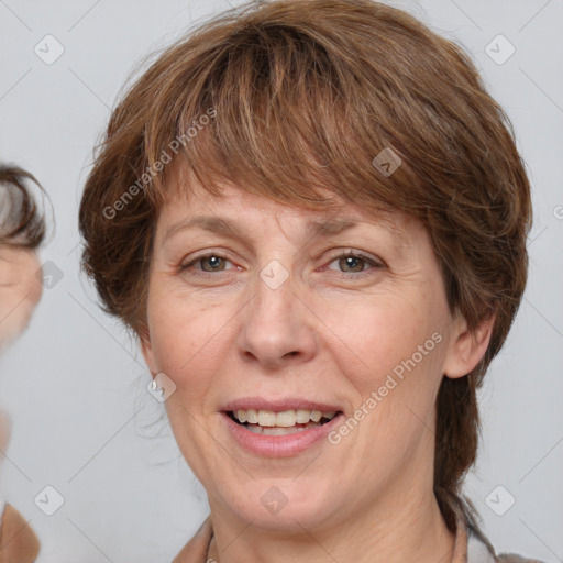 Joyful white adult female with medium  brown hair and grey eyes