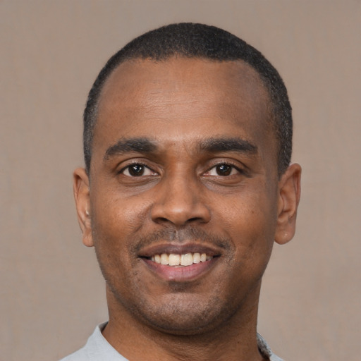 Joyful black young-adult male with short  black hair and brown eyes