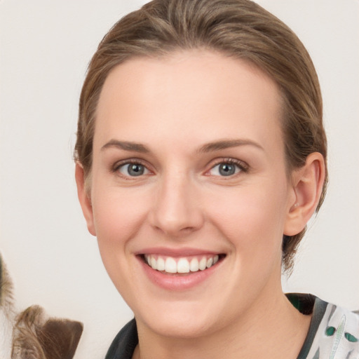 Joyful white young-adult female with medium  brown hair and grey eyes