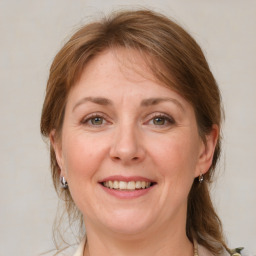 Joyful white adult female with medium  brown hair and green eyes