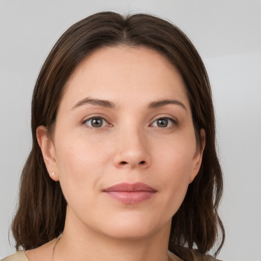 Joyful white young-adult female with medium  brown hair and grey eyes