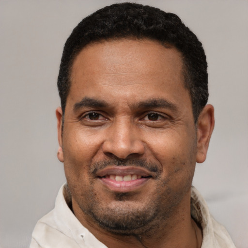 Joyful latino adult male with short  black hair and brown eyes