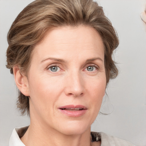 Joyful white adult female with medium  brown hair and blue eyes