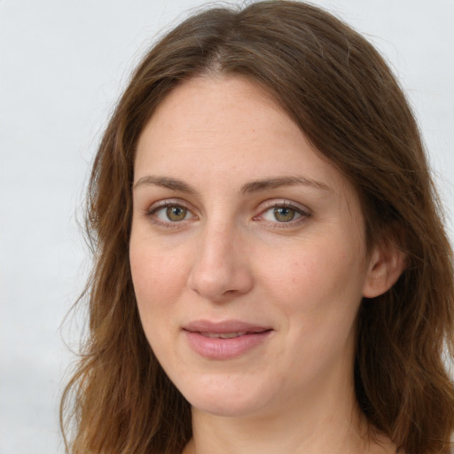 Joyful white young-adult female with long  brown hair and green eyes