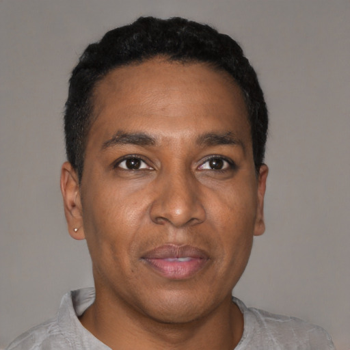 Joyful black young-adult male with short  black hair and brown eyes