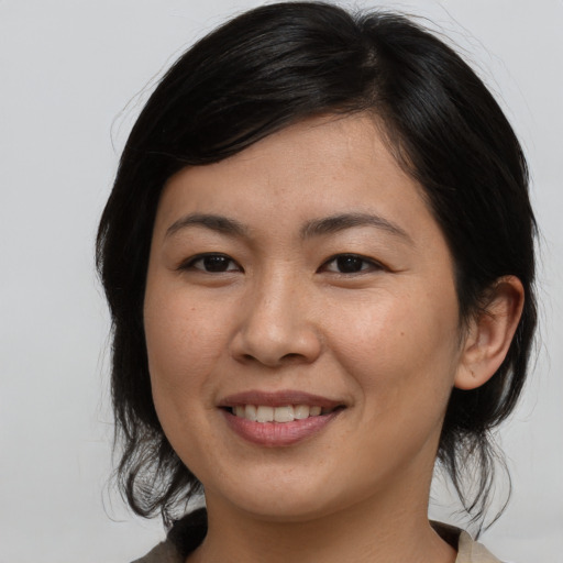 Joyful asian young-adult female with medium  brown hair and brown eyes