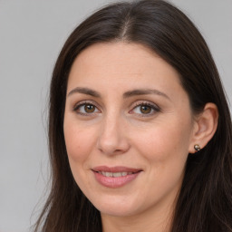 Joyful white adult female with long  brown hair and brown eyes