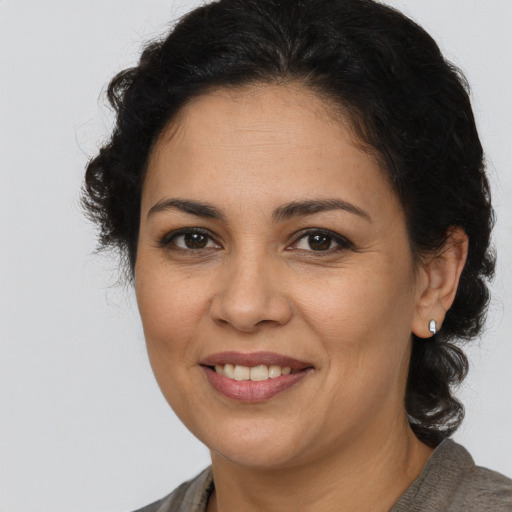 Joyful latino adult female with medium  brown hair and brown eyes