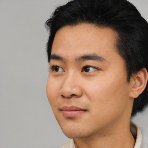 Joyful asian young-adult male with short  black hair and brown eyes