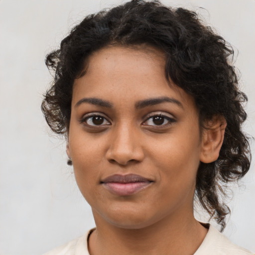 Joyful black young-adult female with medium  brown hair and brown eyes