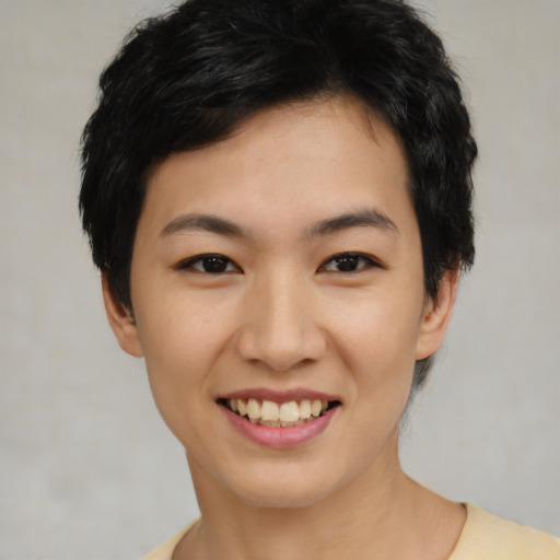 Joyful asian young-adult female with short  black hair and brown eyes