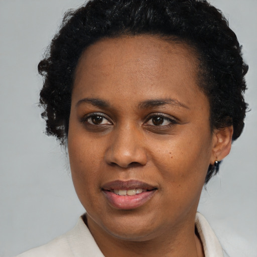 Joyful black adult female with short  black hair and brown eyes