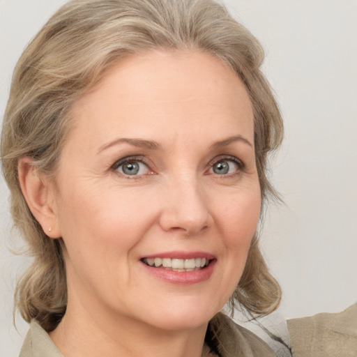 Joyful white adult female with medium  brown hair and grey eyes