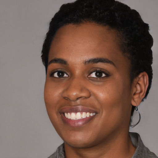 Joyful black young-adult female with medium  black hair and brown eyes