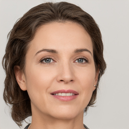 Joyful white young-adult female with medium  brown hair and green eyes