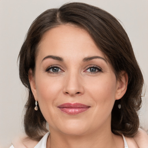 Joyful white adult female with medium  brown hair and brown eyes