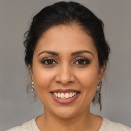 Joyful latino young-adult female with medium  brown hair and brown eyes