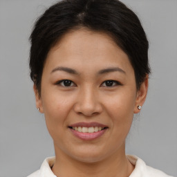 Joyful asian young-adult female with short  brown hair and brown eyes