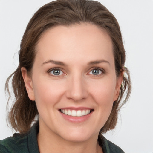 Joyful white young-adult female with medium  brown hair and grey eyes