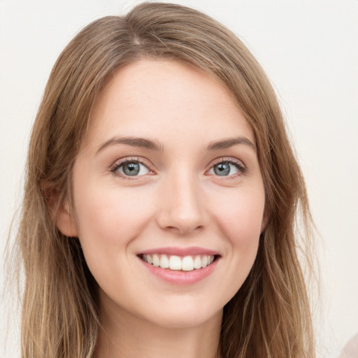 Joyful white young-adult female with long  brown hair and green eyes