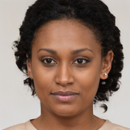 Joyful black young-adult female with long  brown hair and brown eyes