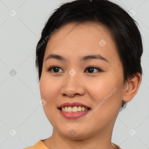 Joyful asian young-adult female with short  black hair and brown eyes