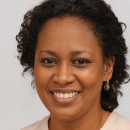 Joyful black adult female with medium  brown hair and brown eyes