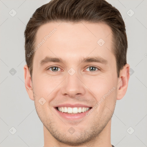 Joyful white young-adult male with short  brown hair and grey eyes