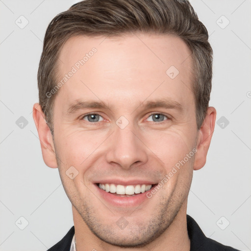 Joyful white young-adult male with short  brown hair and grey eyes