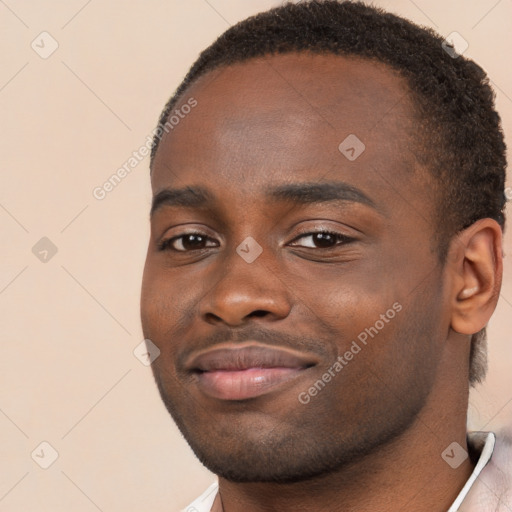 Joyful black young-adult male with short  brown hair and brown eyes