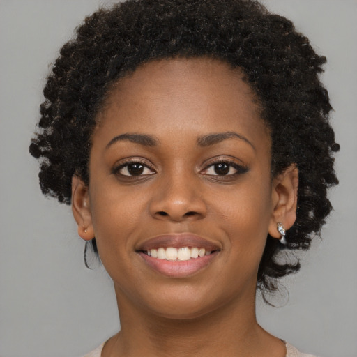 Joyful black young-adult female with long  black hair and brown eyes