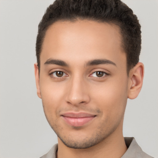 Joyful latino young-adult male with short  brown hair and brown eyes