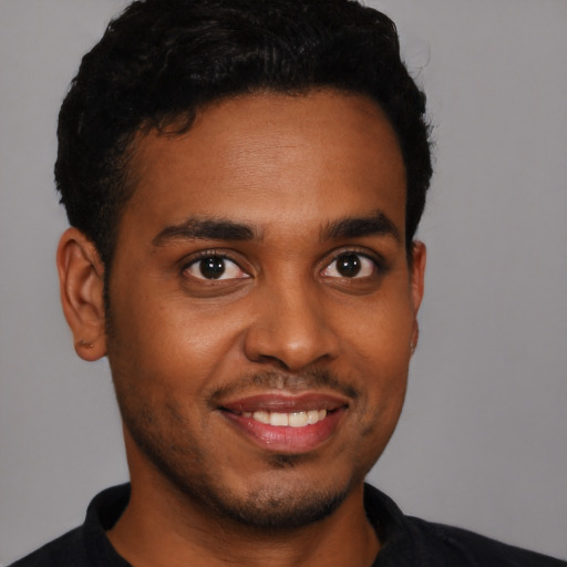 Joyful black young-adult male with short  black hair and brown eyes