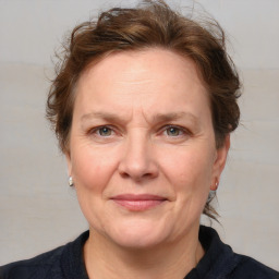 Joyful white adult female with medium  brown hair and blue eyes