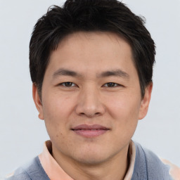 Joyful asian young-adult male with short  brown hair and brown eyes