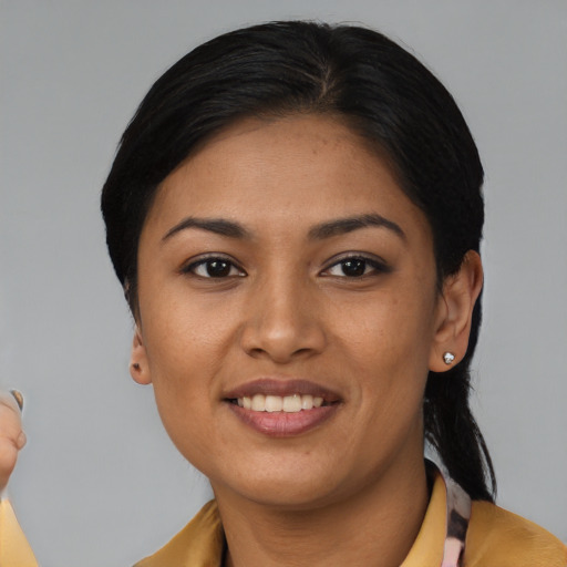 Joyful latino young-adult female with short  black hair and brown eyes