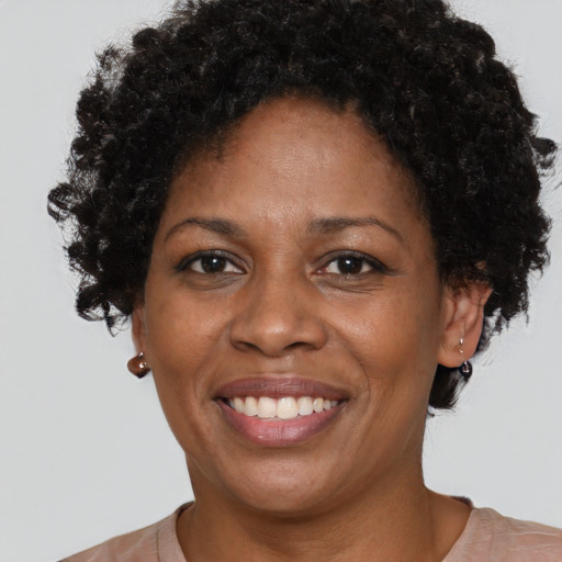 Joyful black adult female with short  brown hair and brown eyes