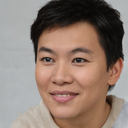 Joyful asian young-adult male with short  brown hair and brown eyes