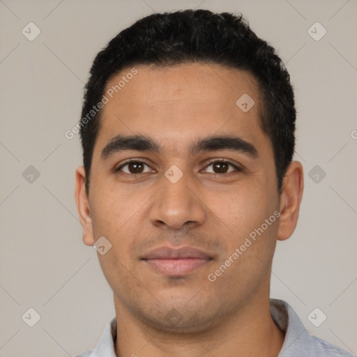 Joyful latino young-adult male with short  black hair and brown eyes