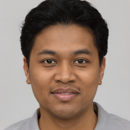 Joyful black young-adult male with short  black hair and brown eyes