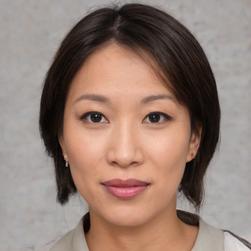 Joyful asian young-adult female with medium  brown hair and brown eyes