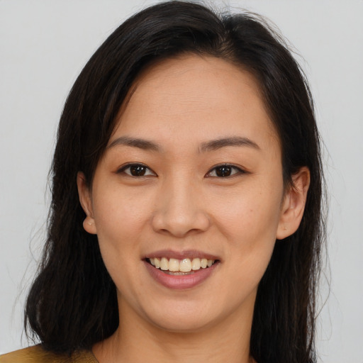 Joyful asian young-adult female with long  brown hair and brown eyes