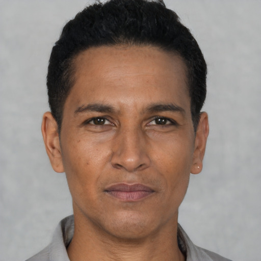 Joyful latino adult male with short  black hair and brown eyes