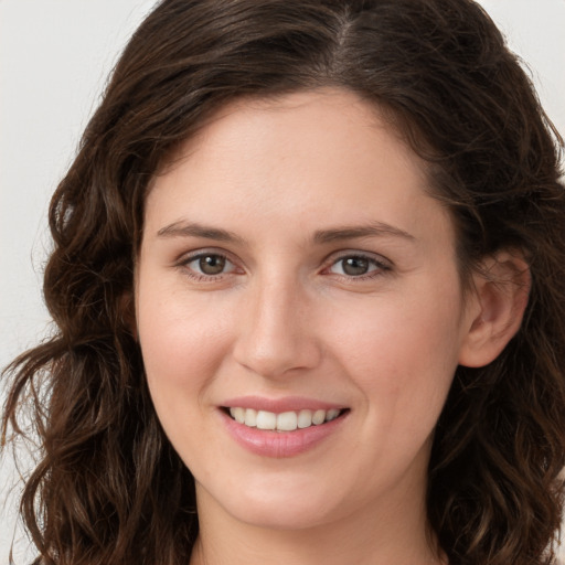 Joyful white young-adult female with long  brown hair and green eyes