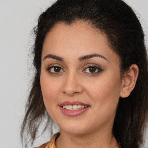 Joyful white young-adult female with long  brown hair and brown eyes